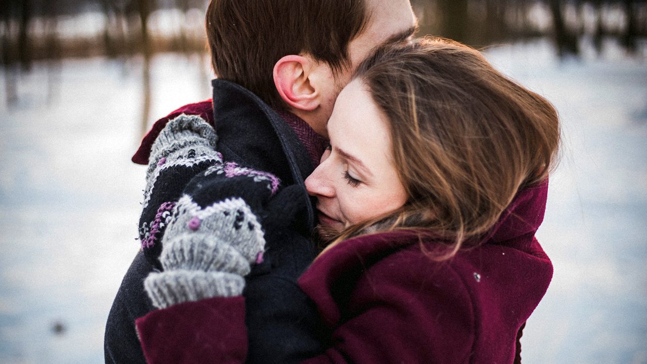 Married couple hugging outside in the snow