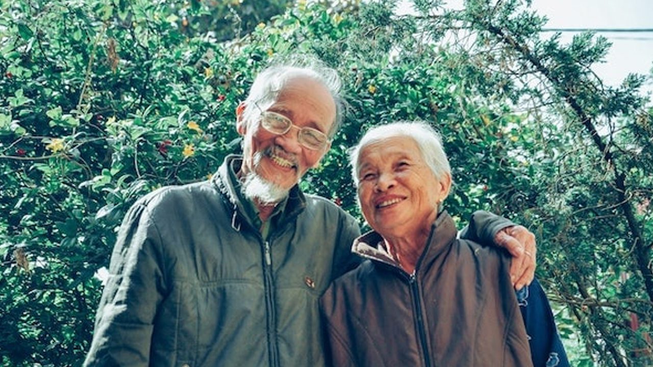 Elderly couple holding each other while smiling