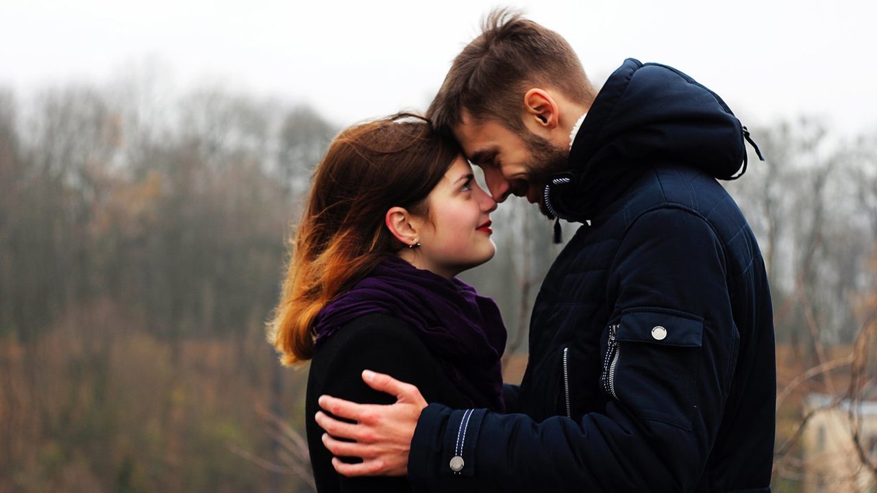 Married couple embracing each other outside