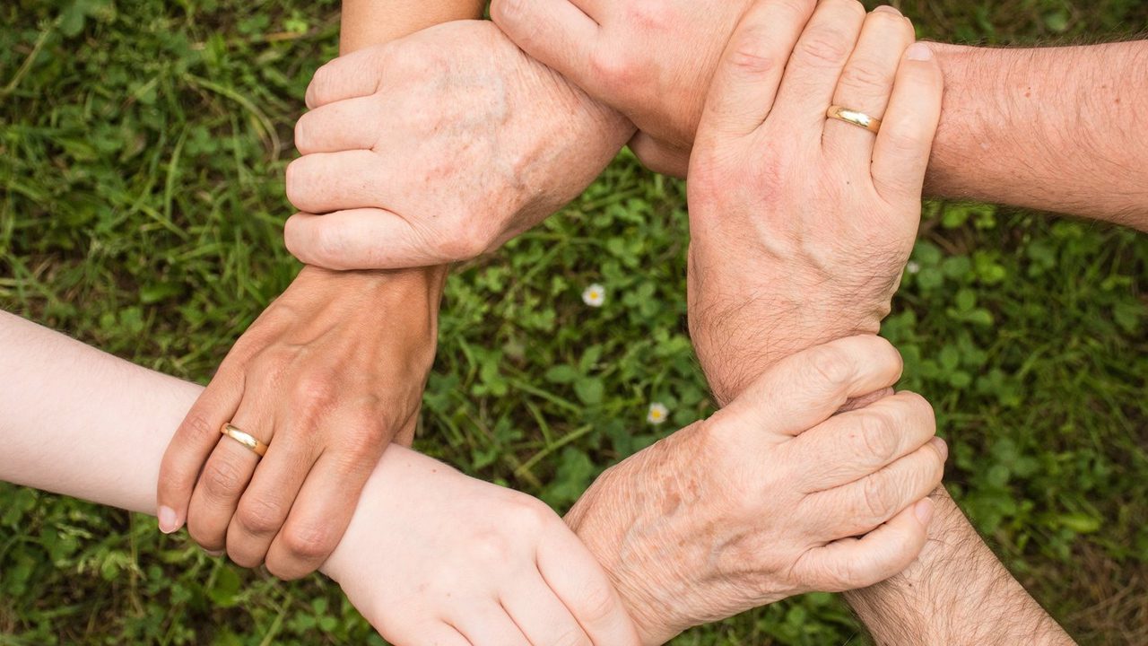 Diverse group of people holding hands in circle