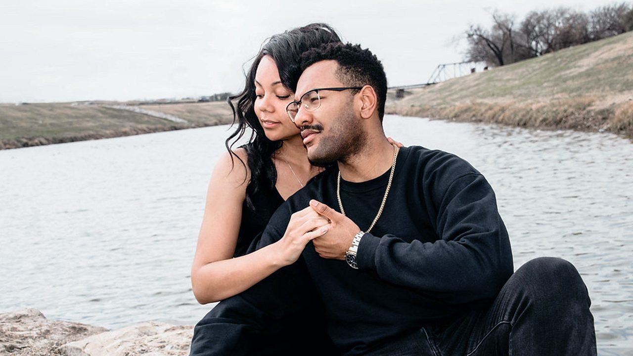 Couple holding hands outside by the water