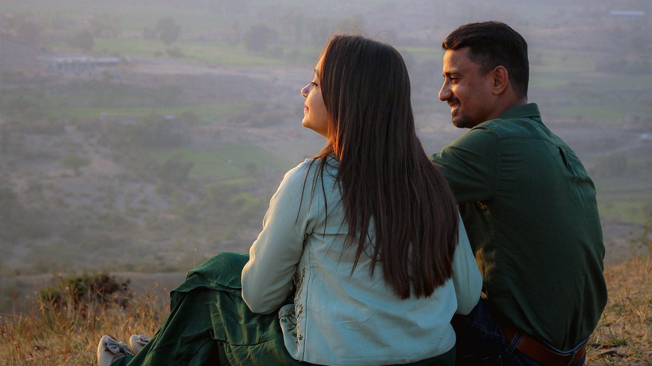 Couple sitting outside looking at the sunset